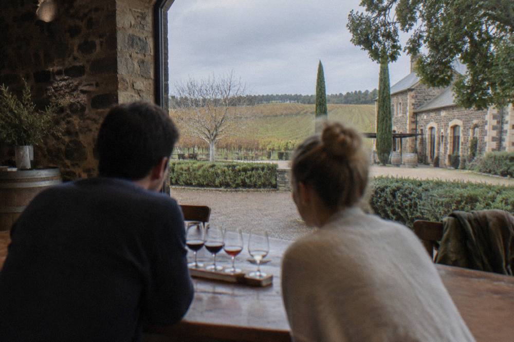 A couple sharing a tasting flight at a Barossa cellar door counter