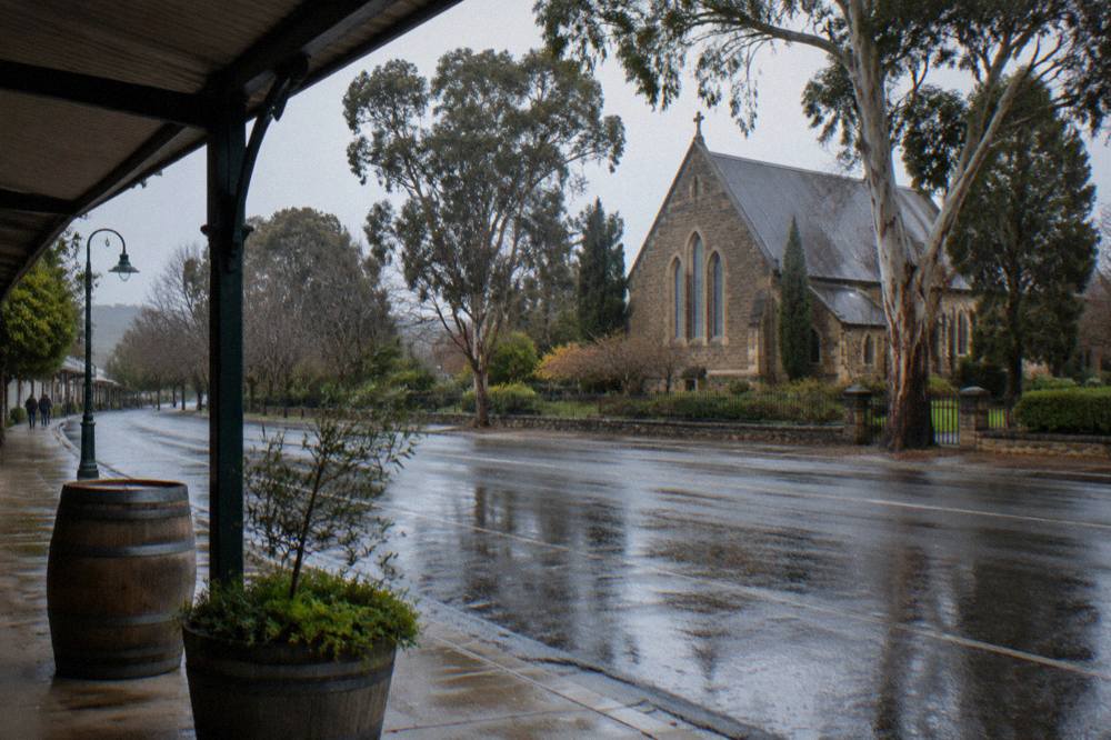 A stone church and historic buildings along a quiet Barossa Valley town street
