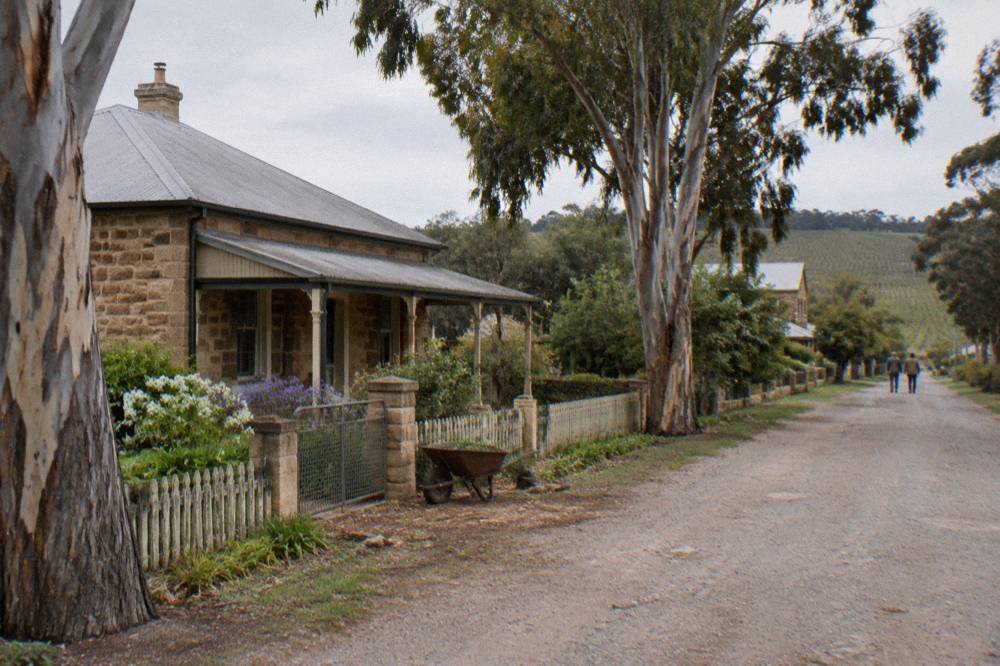 A heritage stone cottage with a verandah in an old Barossa village street
