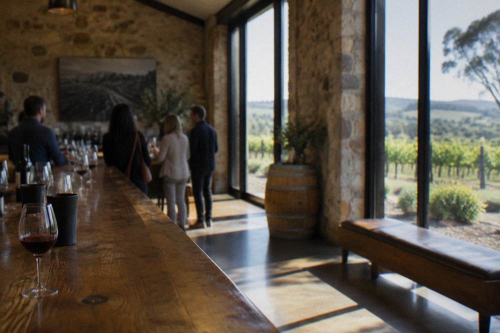 A small group tasting wine at a rustic Barossa cellar door bar with glasses on the counter