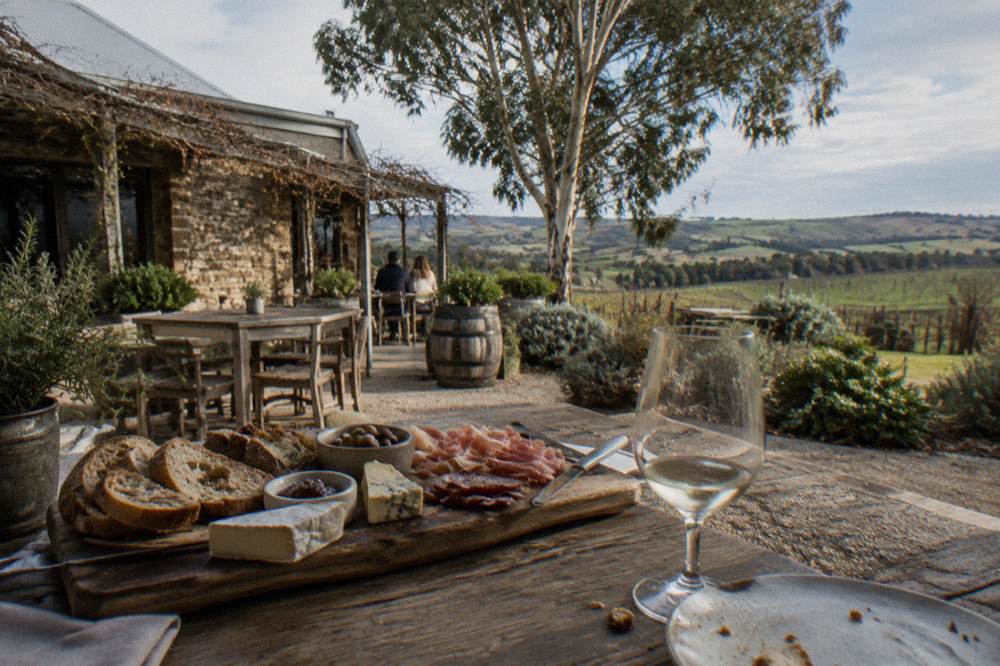 A shared platter of regional cheese, bread and cured meats on a winery table