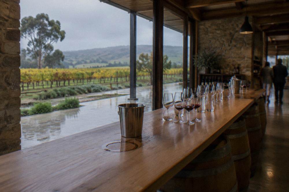 Wooden cellar door tasting counter with glassware set out along a barrel